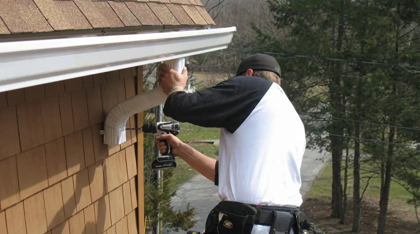 Professional contractor installing tan vinyl siding panels on a residential home exterior in Riverside, CA